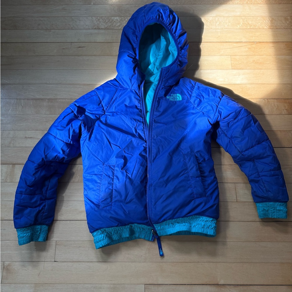 The North Face Kids Blue and Teal Puffer Jacket.  The jacket is reversible.